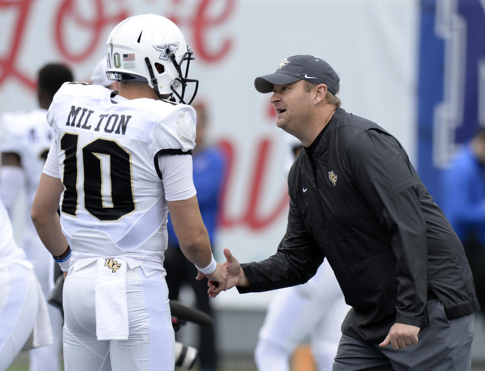 Central Florida head coach Josh Heupel shakes hands with quarterback McKenzie Milton (10) during warm ups before an NCAA college football game against Memphis Saturday, Oct. 13, 2018, in Memphis, Tenn. (AP Photo/Mark Zaleski)