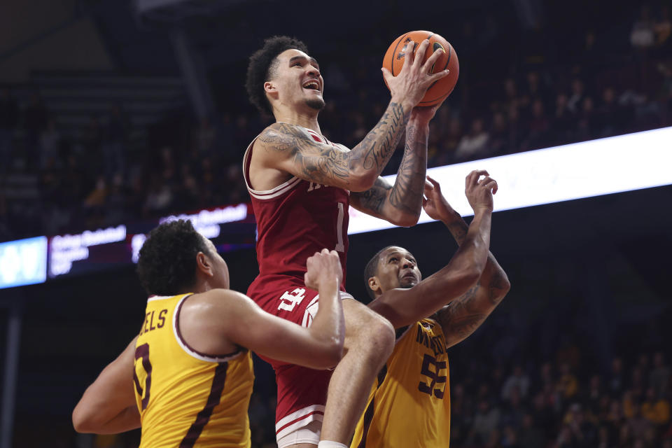 Indiana guard Jalen Hood-Schifino (1) goes up to the basket against Minnesota guards Taurus Samuels (0) and Ta'lon Cooper (55) during the second half of an NCAA college basketball game Wednesday, Jan. 25, 2023, in Minneapolis. Indiana won 61-57. (AP Photo/Stacy Bengs)