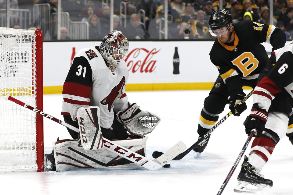 Arizona Coyotes goaltender Adin Hill makes a save as Boston Bruins' Chris Wagner looks for the rebound during the third period of an NHL hockey game Saturday, Feb. 8, 2020, in Boston. (AP Photo/Winslow Townson)