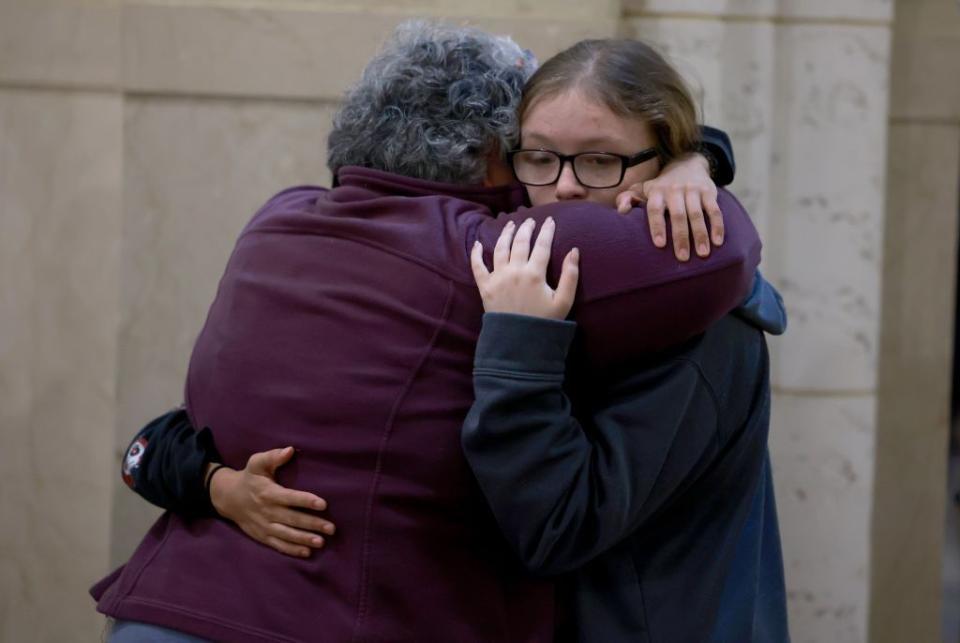 Mourners embrace at the Basilica of Saints Peter and Paul for a remembrance ceremony.