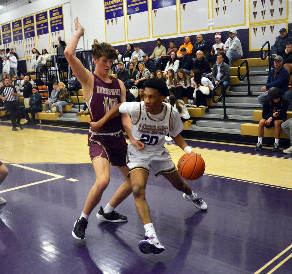 Smithsburg's Jacob Tyler drives the baseline as Brunswick's Mark Cooke defends during the first half of the Leopards' 65-41 victory in a Maryland Class 1A West Region II boys basketball semifinal.