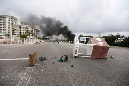 A toppled police post is seen among rubble after a Shi'ite group set an ambulance and a fire engine on fire at the Federal Secretariat in Abuja