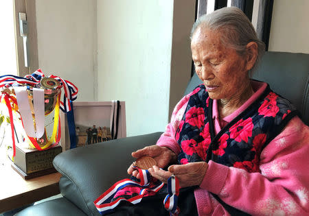 Kim Won-hee, 92-year-old grandmother of Kim Eun-jung, skip of South Korea's Olympic women's curling team, holds medals won by her granddaughter, in Uiseong, South Korea, February 23, 2018.REUTERS/Lucien Libert