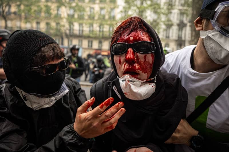 A protestor is hit in the head by a riot police during a charge to disperse the demonstrators. A day full of clashes between the black-block, anarchists and anti-capitalists groups, with the police became the usual on Labour day in Paris, complaining about president Macron's government and his political and social law makings. Axel Miranda/SOPA Images via ZUMA Press Wire/dpa