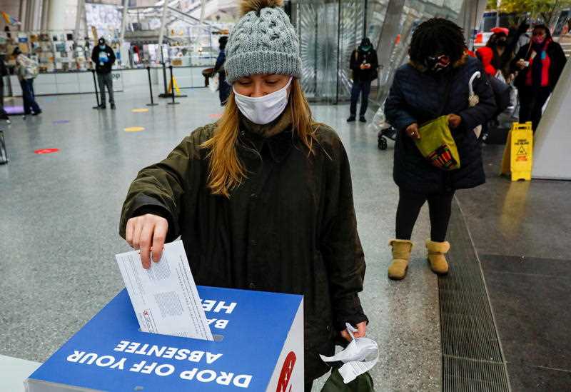 A voter drops off her absentee ballot at a drop box at the Brooklyn Museum in the Brooklyn borough of New York City, New York.