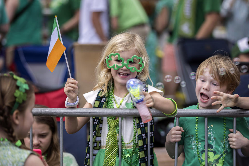 Six-year-old Eloise Tallon of Savannah waves to friends during the St. Patrick's Day parade, Saturday, March 16, 2024, in Savannah, Ga. This is the 200th parade since the first in 1824. (Stephen B. Morton/Atlanta Journal-Constitution via AP)