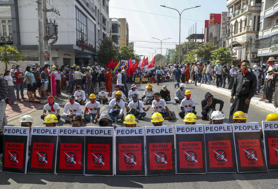 Anti-coup protesters stage a sit-in protest after riot policemen blocked their march in Mandalay, Myanmar, Wednesday, Feb. 24, 2021. Protesters against the military's seizure of power in Myanmar were back on the streets of cities and towns on Wednesday, days after a general strike shuttered shops and brought huge numbers out to demonstrate. (AP Photo)