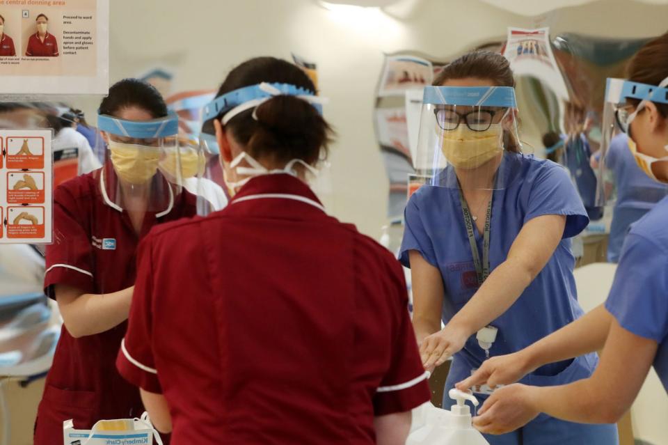 <p>Medical staff don PPE at Craigavon Area Hospital in Co Armagh, Northern Ireland</p> (PA)