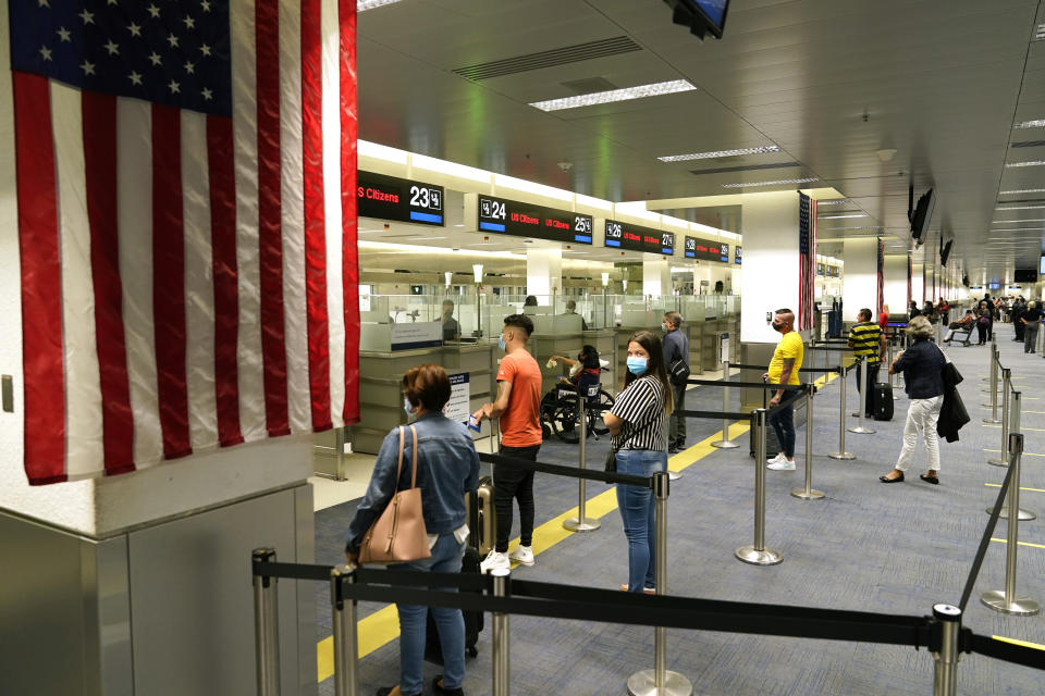 International passengers arrive at Miami international Airport where they are screened by U.S. Customs and Border Protection (CBP) using facial biometrics to automate manual document checks required for admission into the U.S. Friday, Nov. 20, 2020, in Miami. Miami International Airport is the latest airport to provide Simplified Arrival airport-wide. Rising U.S. coronavirus cases, a new round of state lockdowns and public health guidance discouraging trips are dampening enthusiasm for what is usually the biggest travel period of the year. (AP Photo/Lynne Sladky)