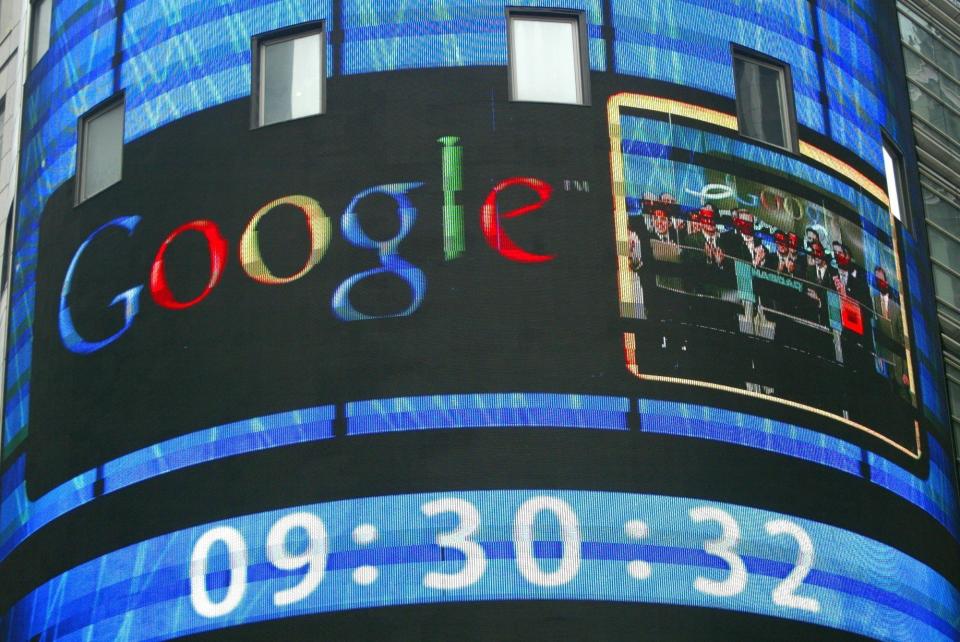 FILE- In this Aug. 19, 2004, file photo the sign outside the Nasdaq Marketsite shows a picture of Goggle staff attending the opening of the Nasdaq market in New York. Twenty years after Larry Page and Sergey Brin set out to organize all of the internet’s information, the search engine they named Google has morphed into a dominating force in smartphones, online video, email, maps and much more. (AP Photo/Kathy Willens, File)