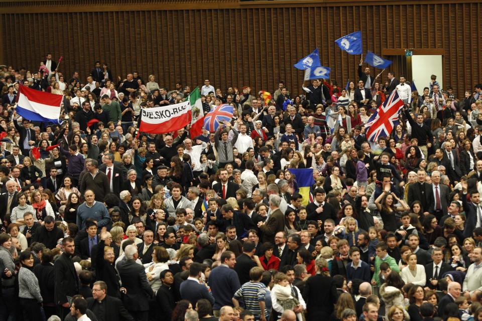 Members of the Neocatechumenal Way missionary movement wave flags as they wait for the arrival of Pope Francis for an audience in the Paul VI hall, at the Vatican, Saturday, Feb. 1, 2014. Francis met with thousands members of the Neocatechumenal Way, a community founded in Spain in the 1960s that seeks to train Catholic adults in their faith and is known for sending large families as missionaries around the world. (AP Photo/Riccardo De Luca)