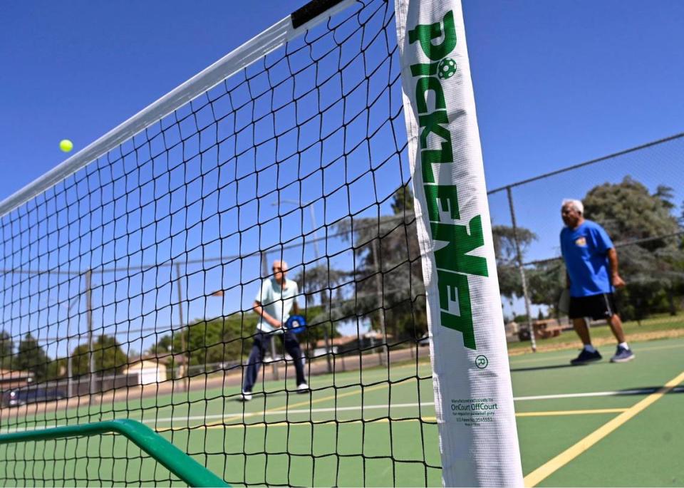 Members of the Fresno Area Pickleball group play at Rotary East Park Wednesday morning, June 21, 2023 in Fresno. The court is a hybrid court, with pickleball lines added to existing tennis court lines.