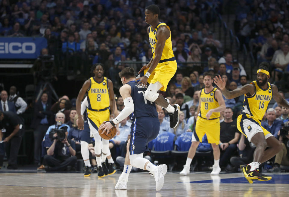 Dallas Mavericks guard Luka Doncic (77) is fouled by Indiana Pacers guard Edmond Sumner (5) during the first half of an NBA basketball game, Sunday, March 8, 2020, in Dallas. (AP Photo/Ron Jenkins)