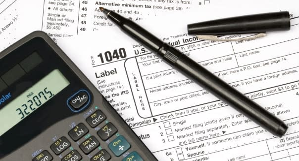 Tax forms a calculator and a pen showing the readiness to do ones taxes