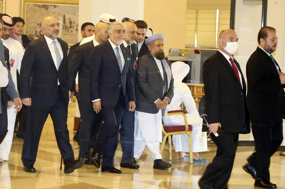 Abdullah Abdullah, center, chairman of Afghanistan's High Council for National Reconciliation, arrives wit his delegation for the opening session of the peace talks between the Afghan government and the Taliban in Doha, Qatar, Saturday, Sept. 12, 2020. (AP Photo/Hussein Sayed)