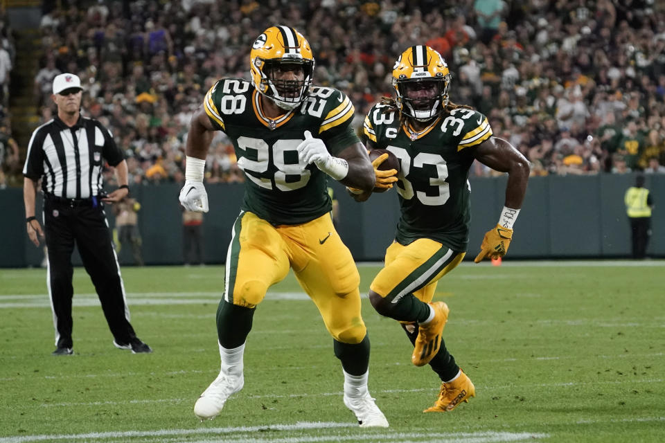 Green Bay Packers running back Aaron Jones (33) runs behind teammate running back AJ Dillon (28) during an 8-yard touchdown reception during the first half of an NFL football game against the Chicago Bears Sunday, Sept. 18, 2022, in Green Bay, Wis. (AP Photo/Morry Gash)