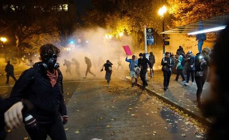 People try to move away from a gas cloud during a protest against the election of Republican Donald Trump as President of the United States in Portland, Oregon, U.S. November 12, 2016. REUTERS/William Gagan