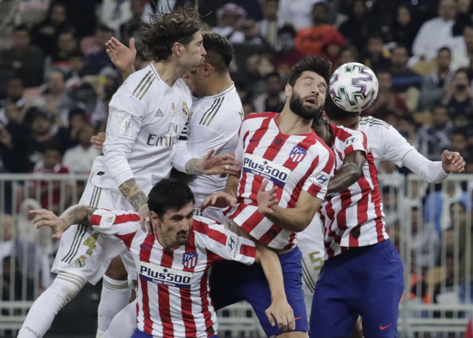 Atletico Madrid's players and Real Madrid's players jump for the ball during the Spanish Super Cup Final soccer match between Real Madrid and Atletico Madrid at King Abdullah stadium in Jiddah, Saudi Arabia, Sunday, Jan. 12, 2020. (AP Photo/Hassan Ammar)