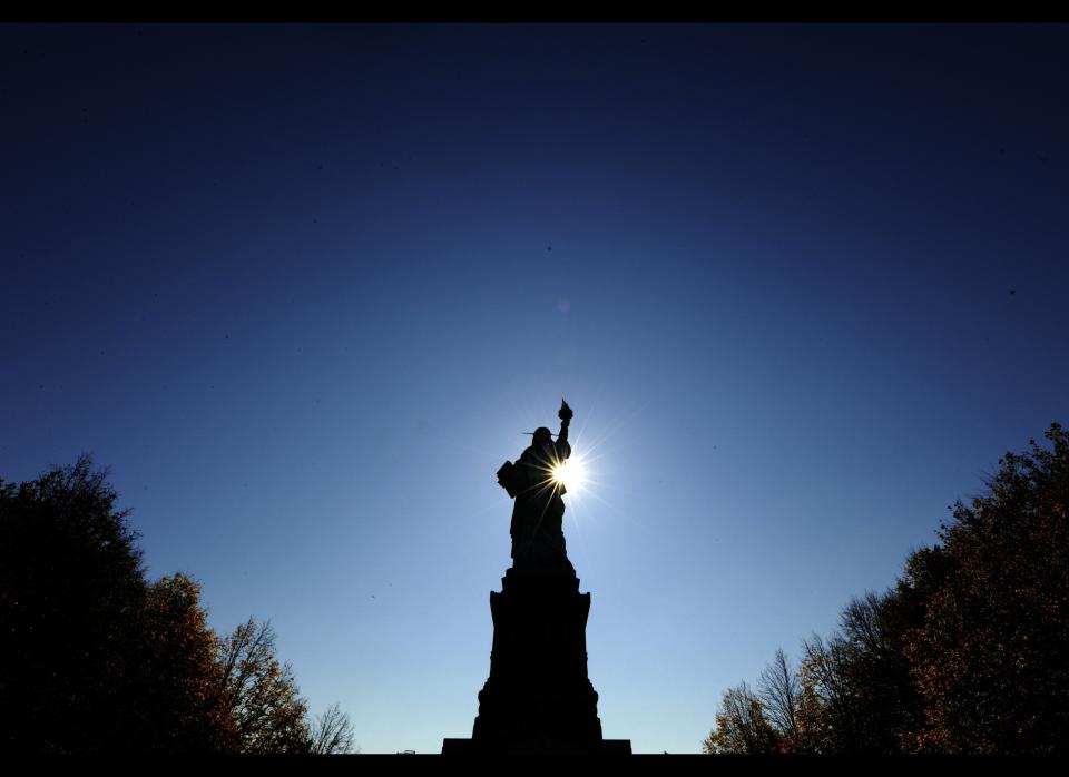 The sun rises in front of the Statue of Liberty before the start of a ceremonies on Liberty Island in New York on October 28, 2011 to commemorate the 125th anniversary of the dedication of the Statue of Liberty.   AFP PHOTO / TIMOTHY A. CLARY (Photo credit should read TIMOTHY A. CLARY/AFP/Getty Images)