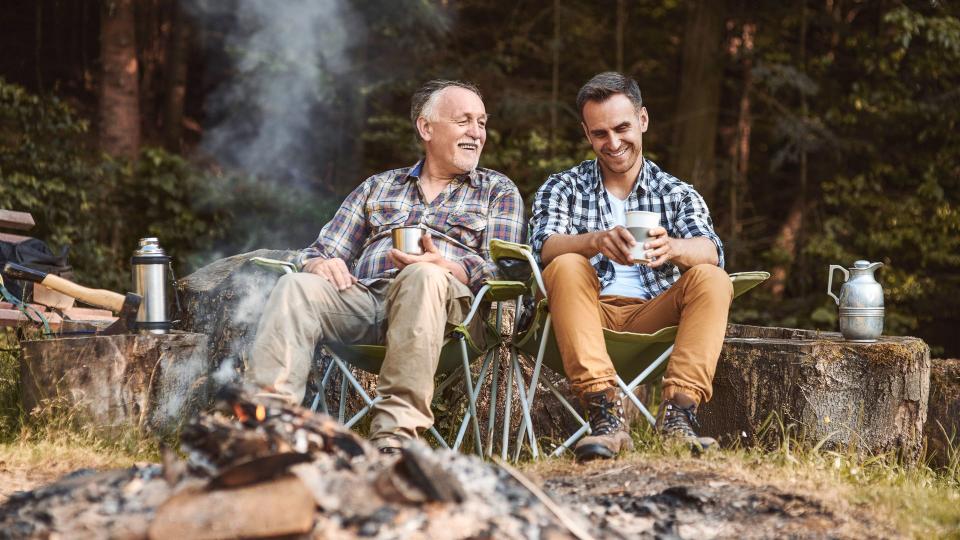 Two fishermen camping in forest.