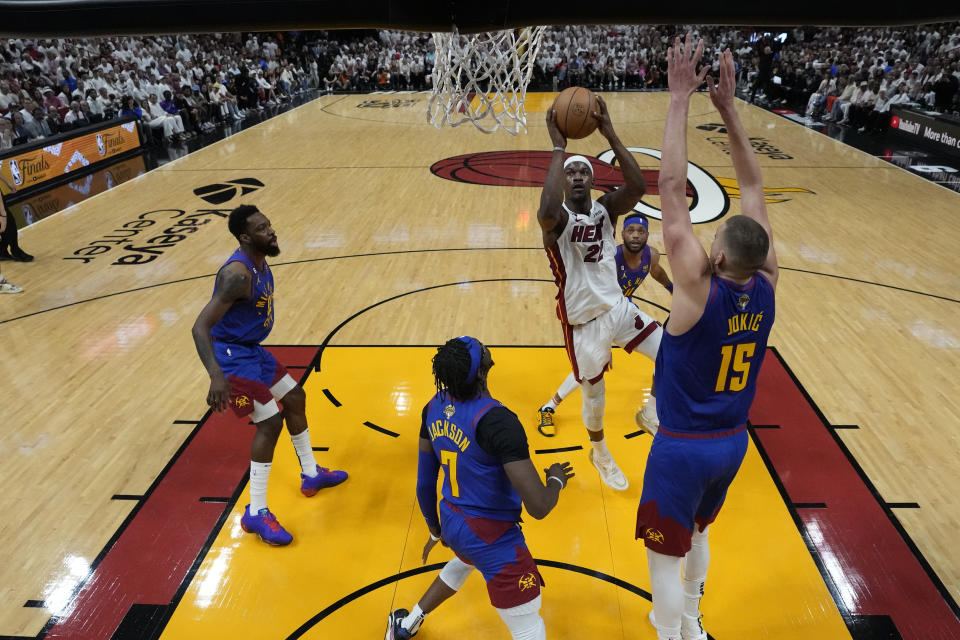 Miami Heat forward Jimmy Butler (22) drives to the basket as Denver Nuggets center Nikola Jokic (15) defends during the first half of Game 3 of the NBA Finals basketball game, Wednesday, June 7, 2023, in Miami. (AP Photo/Wilfredo Lee)