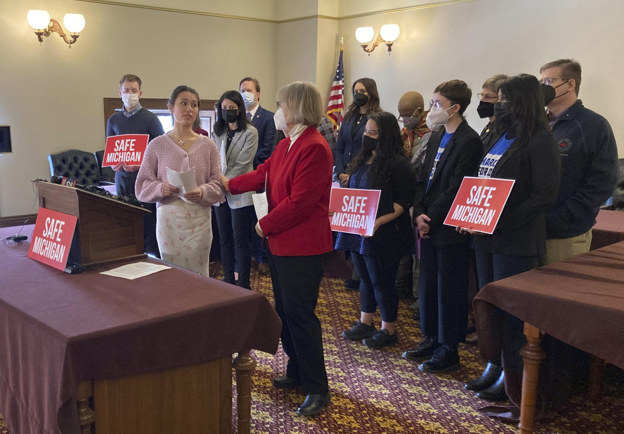 FILE - Reina St. Juliana, a junior at Oxford High School, advocates for safe gun storage legislation, during a news conference Tuesday, Feb. 15, 2022, in the state Capitol in Lansing, Mich. Reina's sister, Hana, was killed in a mass shooting at the school. Reina thanked Sen. Rosemary Bayer, front right, D-Beverly Hills, for sponsoring the bill. (AP Photo/David Eggert, File)