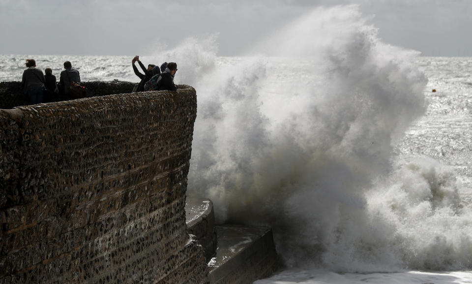 Visitors to Brighton brave the elements to take selfies (Picture: PA)