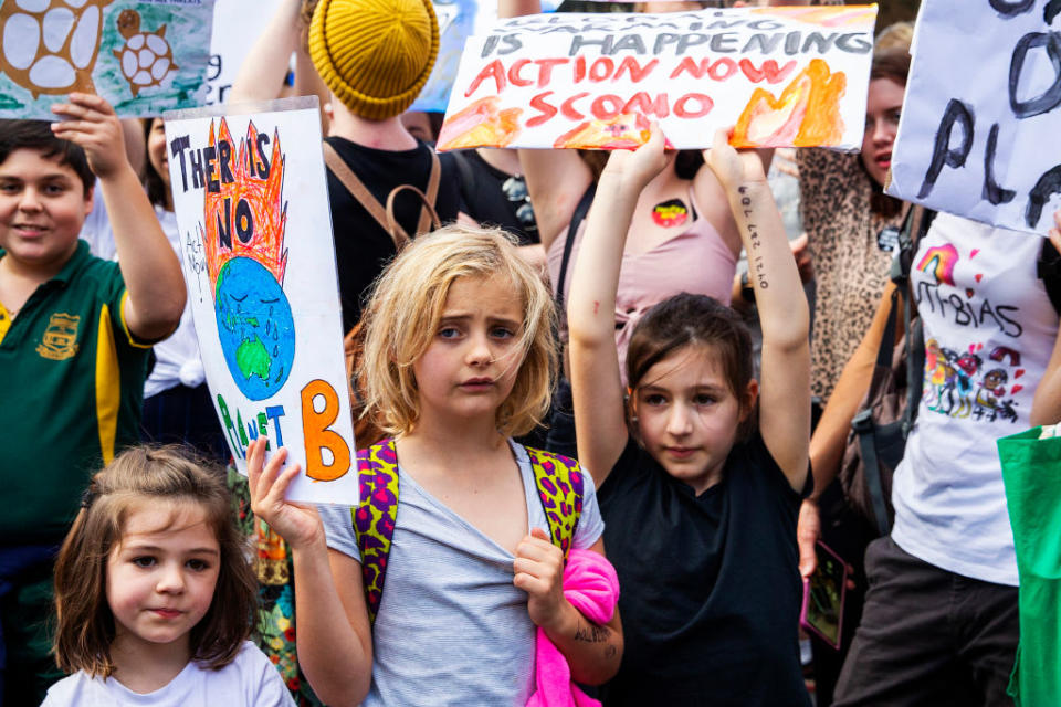 Children holding up signs during a climate strike rally outside Parliament House.