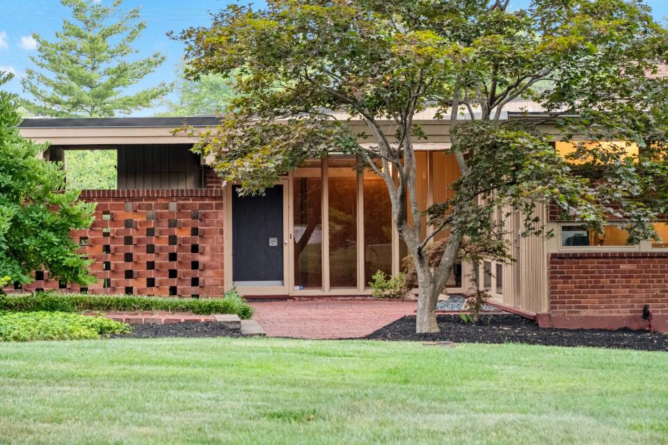 Set on a lush lot, the historic home presents a contrasting palette of brick, glass, and wood. As with many of Shank's designs, the residence prioritizes privacy with a brick screen wall.