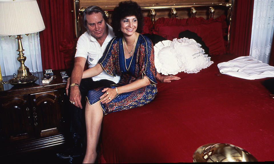 George Jones and Nancy Jones sit on bed in their home