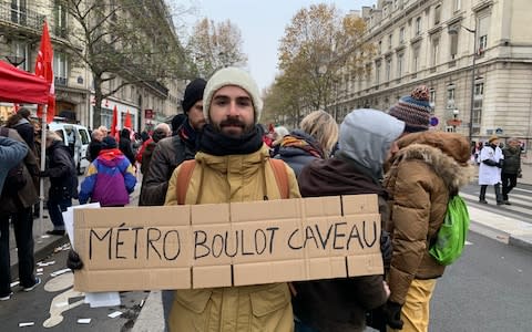 Luc Angelini, 28, who works in publishing, in the Paris protest against pension reform, with a banner reading: "Metro, work, grave." - Credit: Henry Samuel