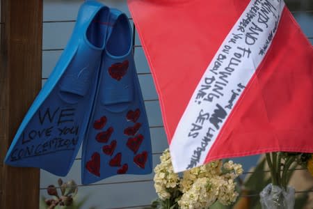 FILE PHOTO: A diving flag and fins hang on a makeshift memorial near Truth Aquatics as the search continues for those missing in a pre-dawn fire that sank a commercial diving boat off Santa Barbara, California,