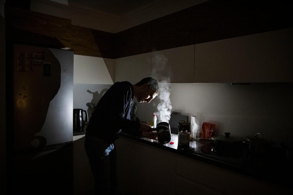 IT worker Igor, who normally uses an electric hob, makes tea using a camping stove at home during a scheduled power cut last night in Kyiv (Getty)