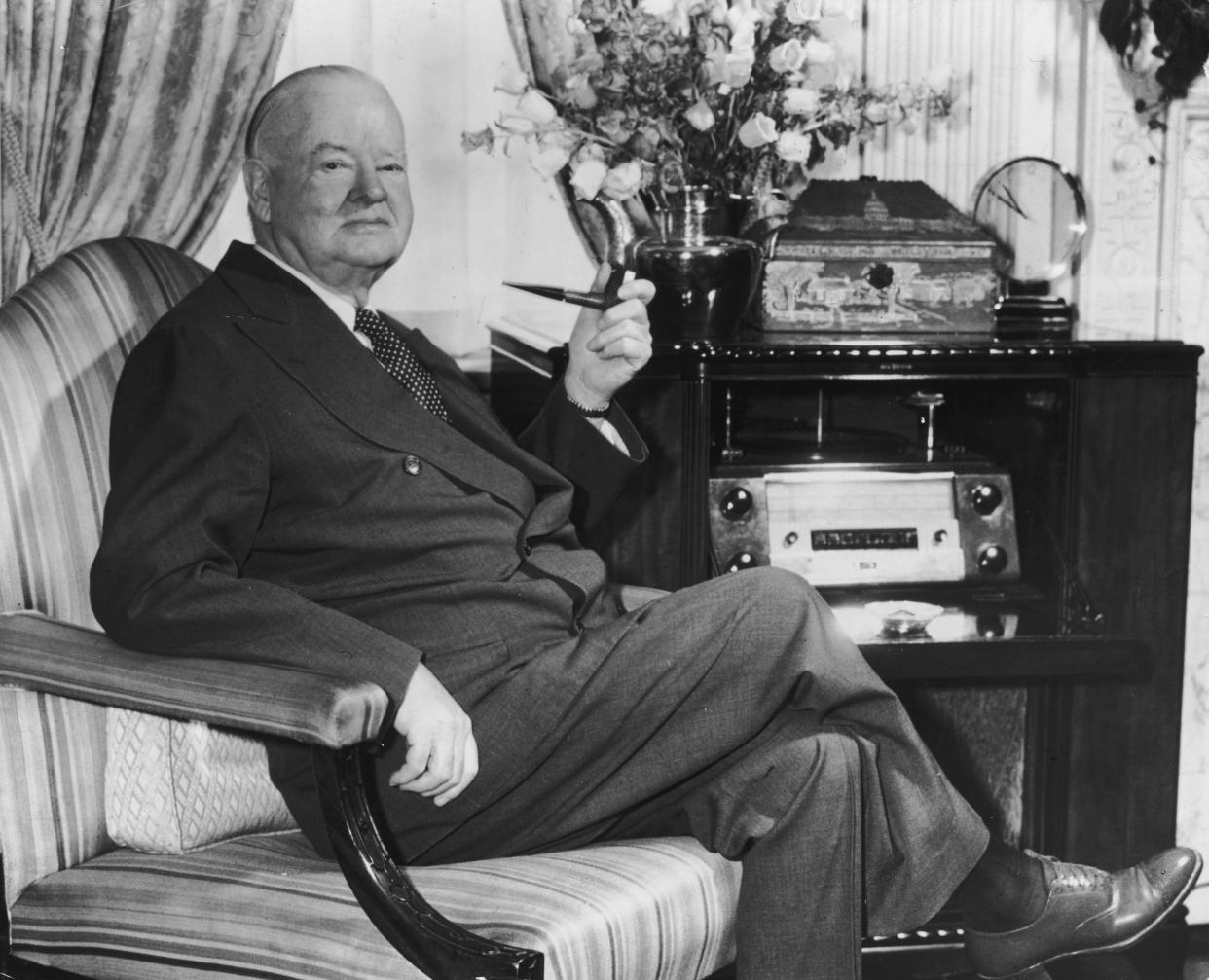 circa 1962:  Portrait of former American president Herbert Hoover (1874 - 1964) seated in an armchair with a pipe in his suite at the Waldorf Towers, New York City.  (Photo by Hulton Archive/Getty Images)