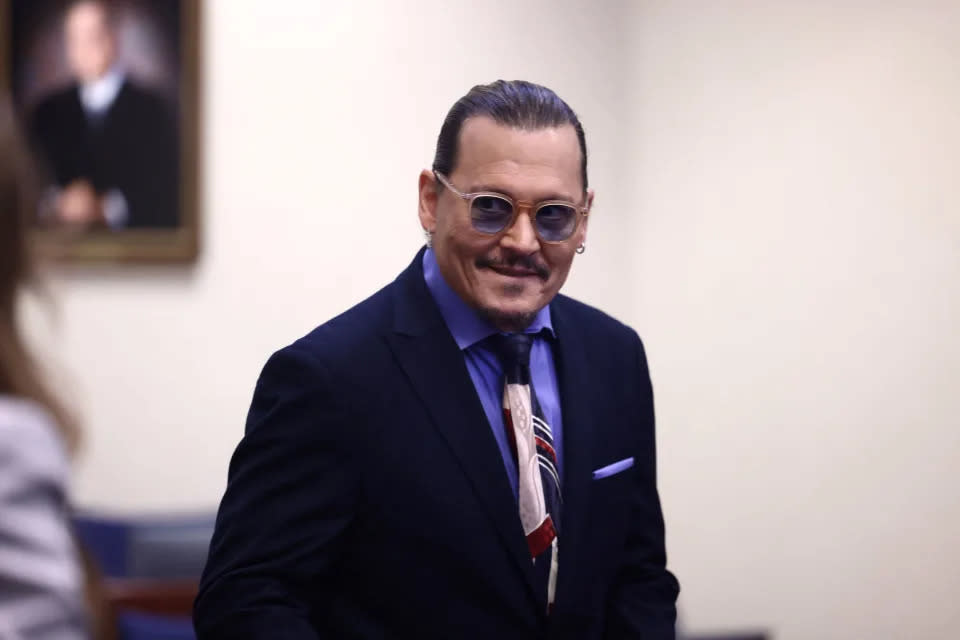 Johnny Depp sorri em sessão do julgamento realizada nesta quinta-feira (5), nos Estados Unids (Foto: JIM LO SCALZO / POOL/POOL/AFP via Getty Images)
