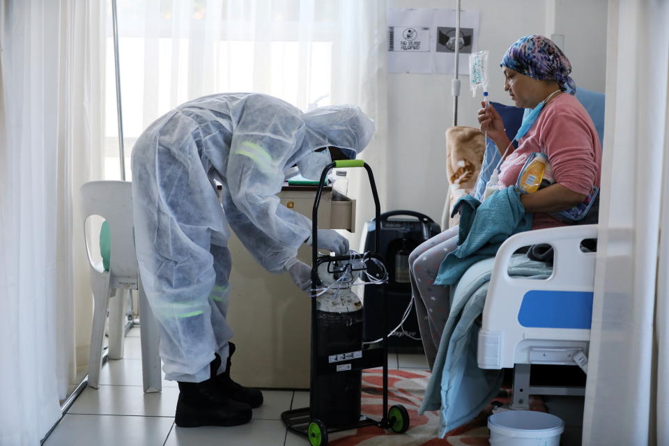 A healthcare worker assists a patient being treated at a makeshift hospital run by charity organisation The Gift of the Givers, during the coronavirus disease (COVID-19) outbreak in Johannesburg, South Africa, July 11, 2021. Picture taken July 11, 2021. REUTERS/ Sumaya Hisham