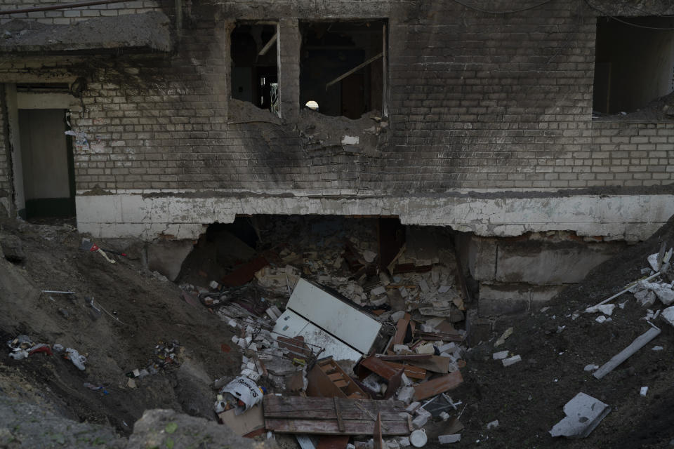 A crater from an explosion is seen next to a heavily damaged apartment and a basement of a residential building that killed, according to the residents, a 8-year-old girl during a Russian attack yesterday, in Lyman, Ukraine, Tuesday, April 26, 2022. Russia pounded eastern and southern Ukraine on Tuesday as the U.S. promised to "keep moving heaven and earth" to get Kyiv the weapons it needs to repel the new offensive, despite Moscow's warnings that such support could trigger a wider war. (AP Photo/Leo Correa)