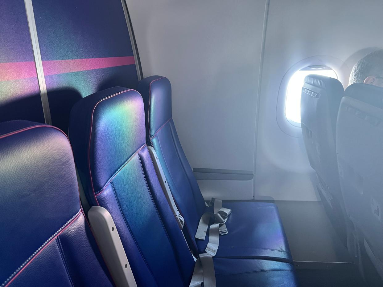 A row of blue seats at the back of a Wizz Air Airbus A321neo  shows there's no window.