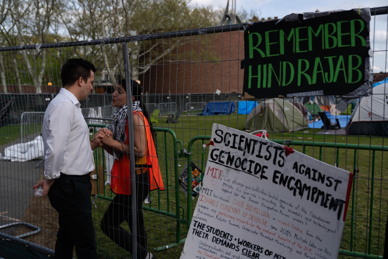 A student and her husband share a moment at a protest encampment fence on the Massachusetts Institute of Technology campus in Cambridge, Mass. on Monday, May 6, 2024. (Sophie Park/The New York Times)