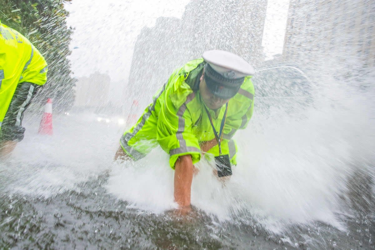 A traffic police officer drains water on a street during a downpour in Nantong, in China’s eastern Jiangsu province (AFP/Getty)
