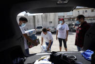 Sidewalk School founder Felicia Rangel-Samponaro, second from right, works works with staff to gather supplies, on Friday, Nov. 20, 2020, in Matamoros, Mexico. Like countless schools, the Sidewalk School went to virtual learning amid the coronavirus pandemic, but instead of being hampered by the change, it has blossomed. (AP Photo/Eric Gay)