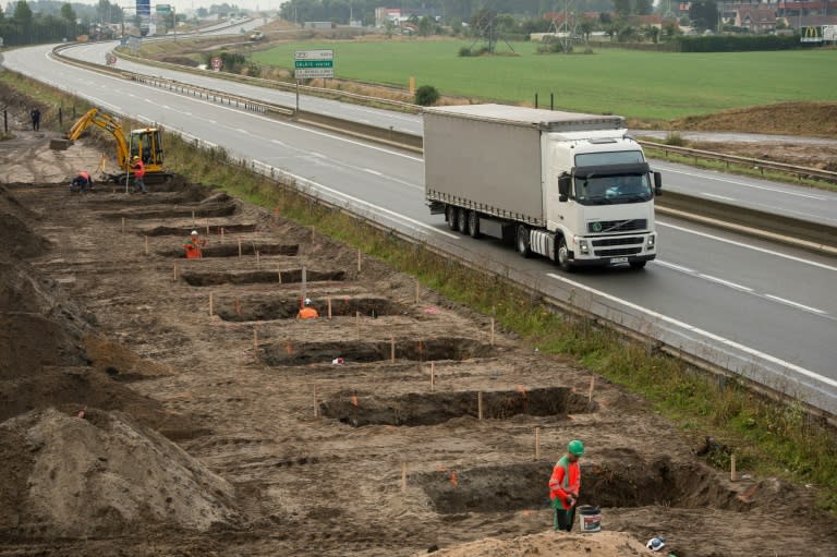 Workers dig foundations of a wall near the Calais migrant camp along the road leading to the harbour to stop migrants from jumping on lorries bound for Britain