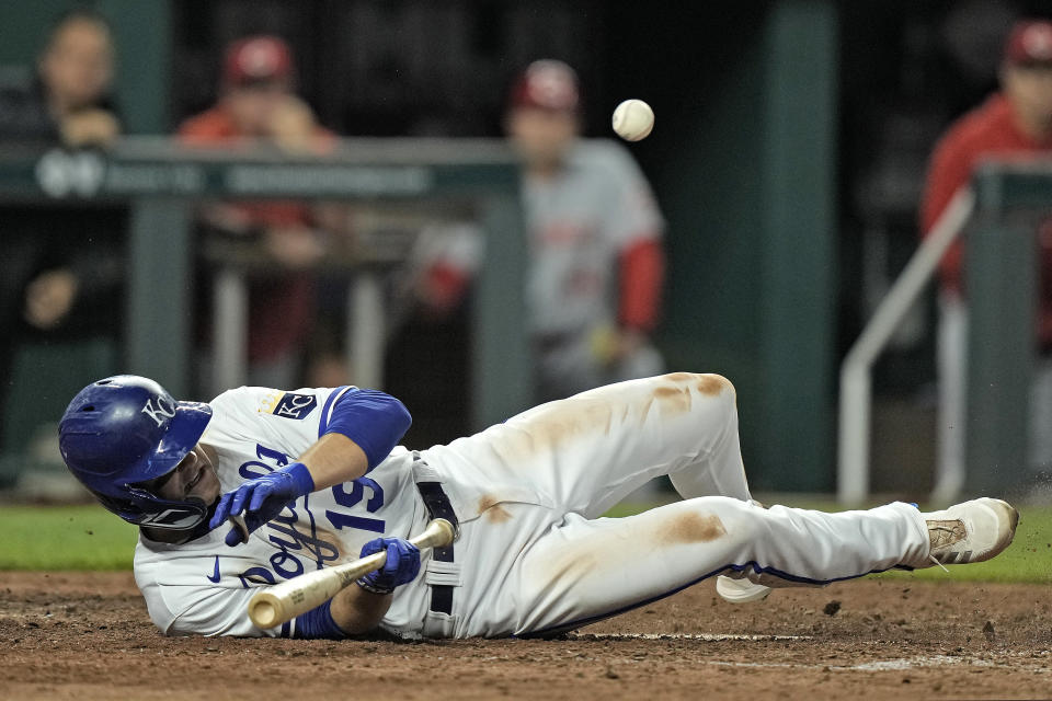 Kansas City Royals' Michael Massey ducks to avoid a wild pitch thrown by Cincinnati Reds relief pitcher Ricky Karcher during the tenth inning of a baseball game Monday, June 12, 2023, in Kansas City, Mo. The Reds won 5-4 in ten innings. (AP Photo/Charlie Riedel)