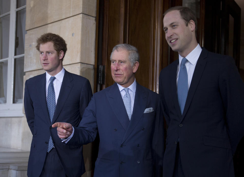 Britain's Prince Charles, center, with his sons Prince William, right, and Prince Harry stops for the media outside Lancaster House as they arrive to attend the Illegal Wildlife Trade Conference in London, Thursday, Feb. 13, 2014. (AP Photo/Alastair Grant, Pool)