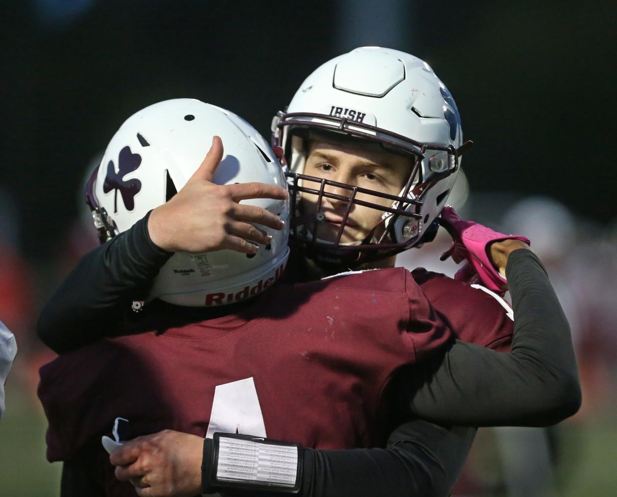 Aquinas quarterback Trent Buttles celebrates with wide receiver Noah Collins-Howard after his touchdown reception on a deep ball from Buttles.