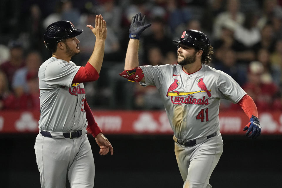 St. Louis Cardinals' Alec Burleson, right, is congratulated by Nolan Arenado after hitting a two-run home run during the seventh inning of a baseball game against the Los Angeles Angels Tuesday, May 14, 2024, in Anaheim, Calif. (AP Photo/Mark J. Terrill)