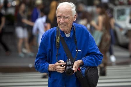 New York Times photographer Bill Cunningham crosses the street after taking photos during New York Fashion Week in the Manhattan borough of New York September 6, 2014. REUTERS/Carlo Allegri/Files