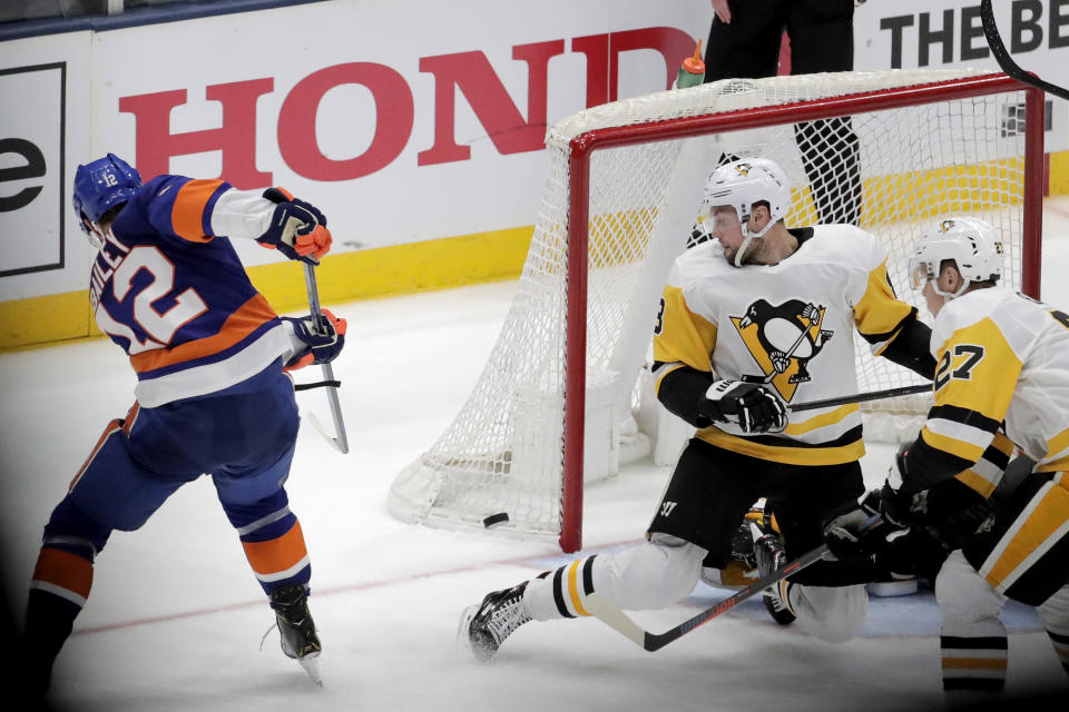 New York Islanders right wing Josh Bailey (12) scores during overtime of Game 1 of an NHL hockey first-round playoff series against the Pittsburgh Penguins, Wednesday, April 10, 2019, in Uniondale, N.Y. The Islanders won 4-3. (AP Photo/Julio Cortez)