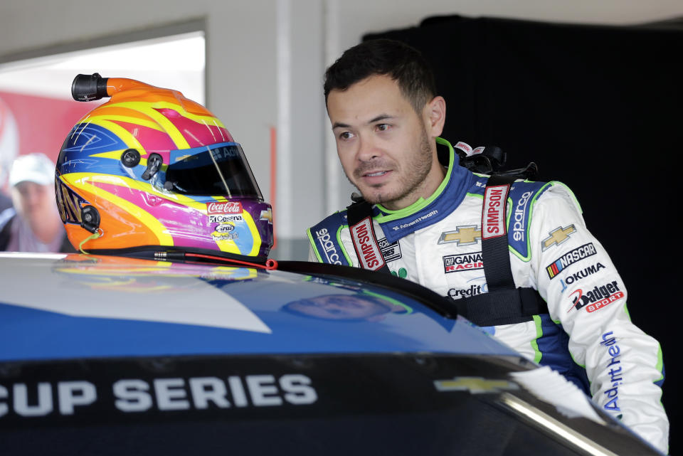 FILE - In this Feb, 8, 2020, file photo, Kyle Larson climbs into his car as he gets ready for a NASCAR auto race practice at Daytona International Speedway, in Daytona Beach, Fla. Larson will be back in NASCAR next season driving the flagship No. 5 Chevrolet for Hendrick Motorsports. Larson signed a multi-year contract Wednesday morning, Oct. 28, 2020, with Hendrick that ended his seven-month banishment from NASCAR for using a racial slur while playing an online racing game. (AP Photo/Terry Renna, File)