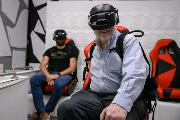 GeekWire’s Alan Boyle (foreground) and University of Washington planetary scientist Baptiste Journaux take a thrill ride through an ice volcano, courtesy of Expedition Titan, a mixed-reality experience at Seattle’s Pacific Science Center. (GeekWire Photo / Kevin Lisota)